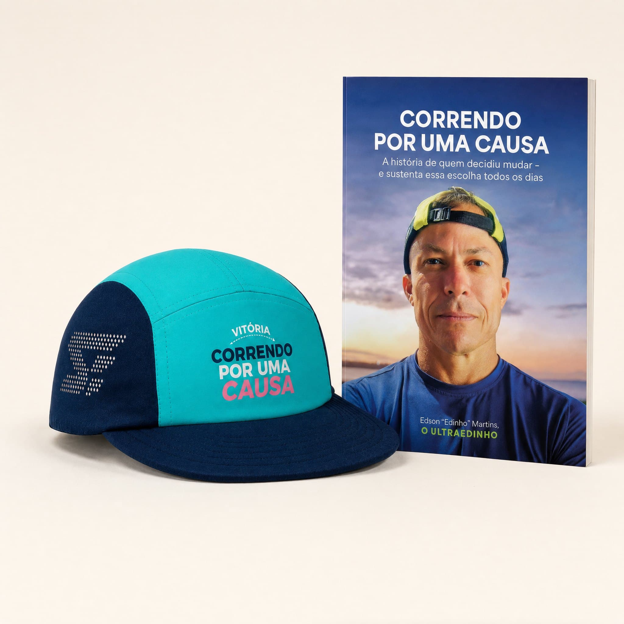 Kit do movimento: boné turquesa e marinho ao lado do livro Correndo por uma Causa em pé, sobre superfície clara de estúdio